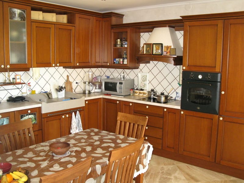 Classic solid wood kitchen in a villa interior in Šušanj, Montenegro: built-in appliances and dining area.