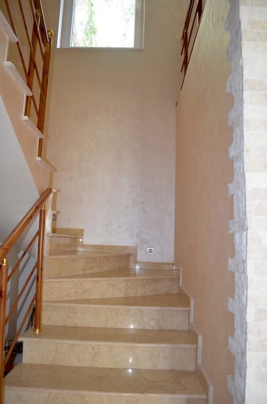Staircase with marble steps and wooden railings in the interior of a villa in Shushan, Montenegro.