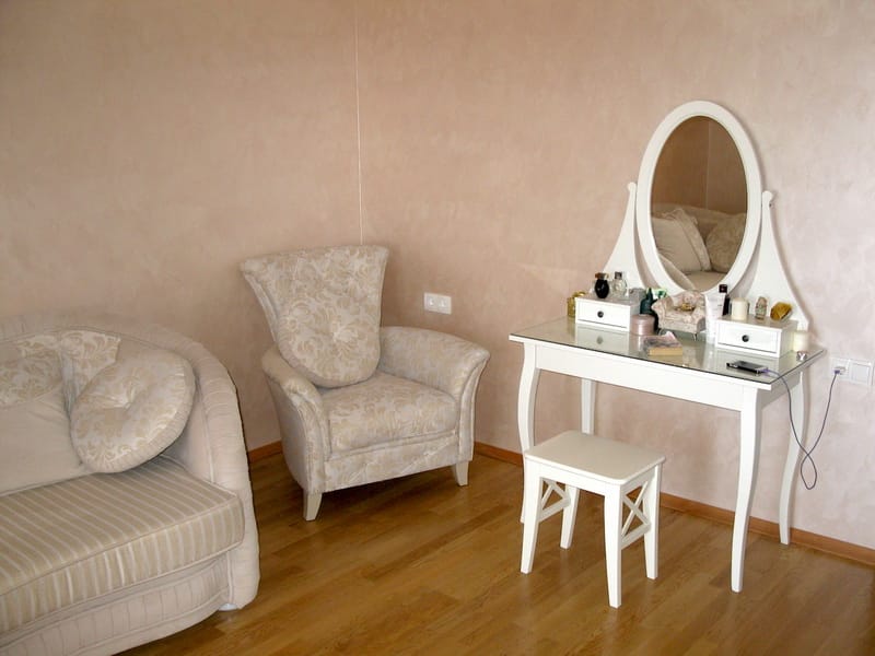 Bedroom with a white vanity, armchair, and sofa in a villa interior in Shushan, Montenegro.