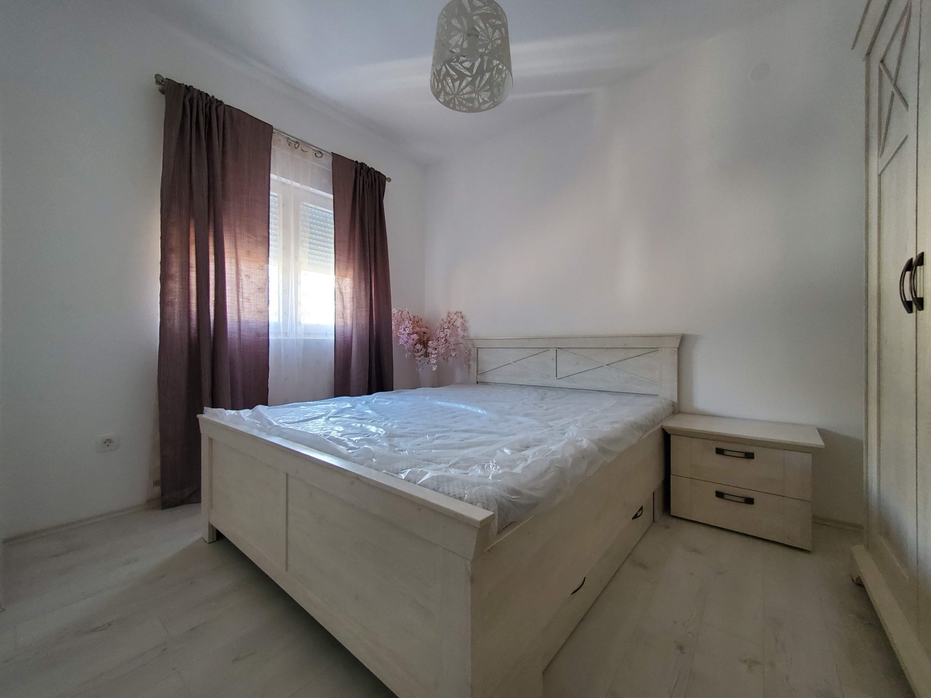 Bright bedroom with a double bed and wardrobe in an apartment for sale in Budva, Montenegro.