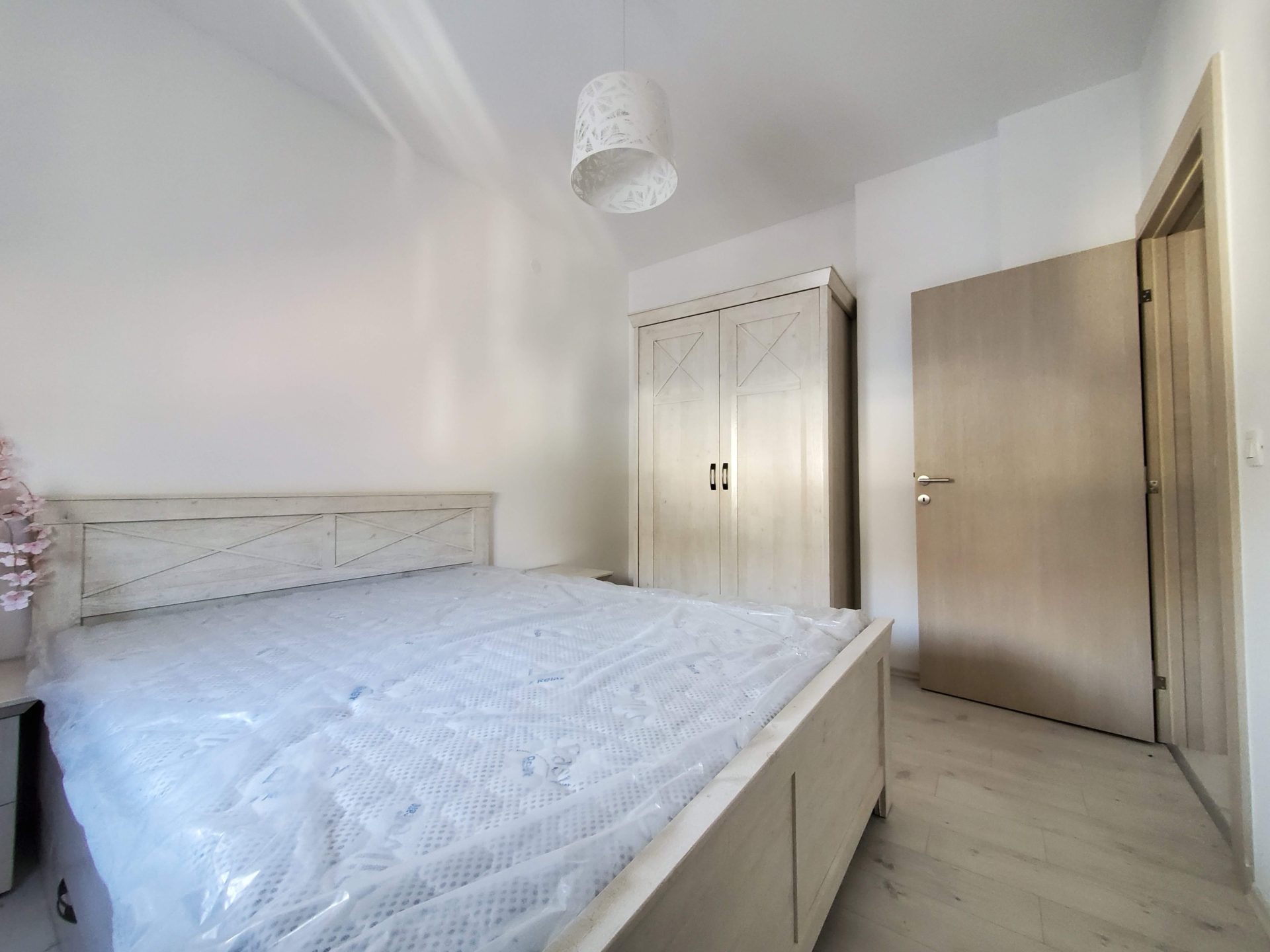 Bright bedroom in an apartment in Budva, Montenegro: double bed with a new mattress, wardrobe, and interior door.