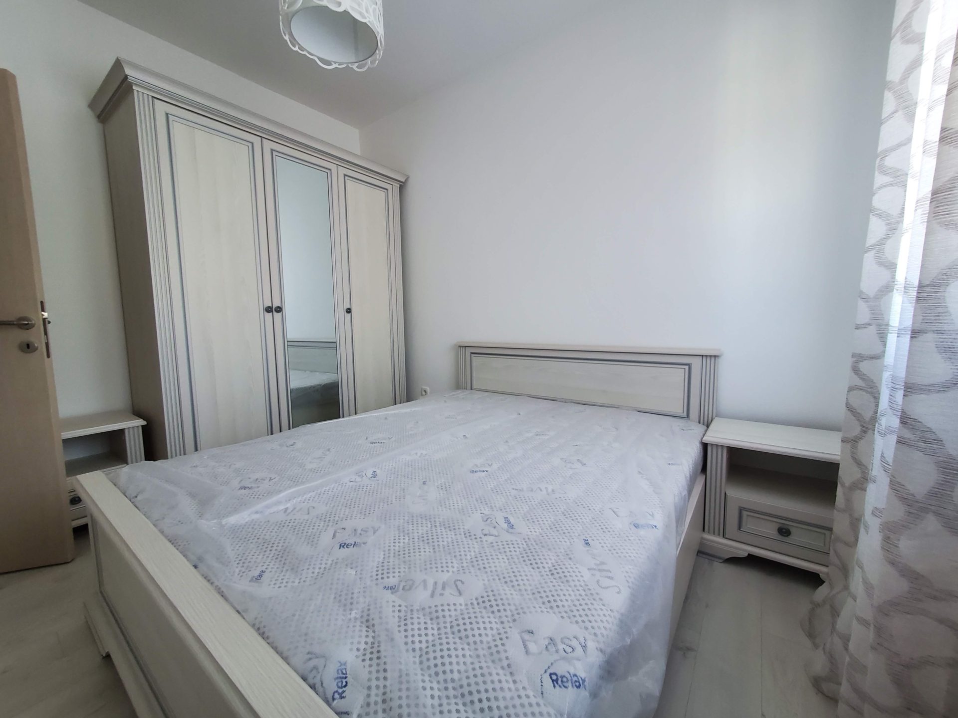 Bright bedroom in an apartment in Budva, Montenegro: double bed, mirrored wardrobe, and bedside tables in light tones