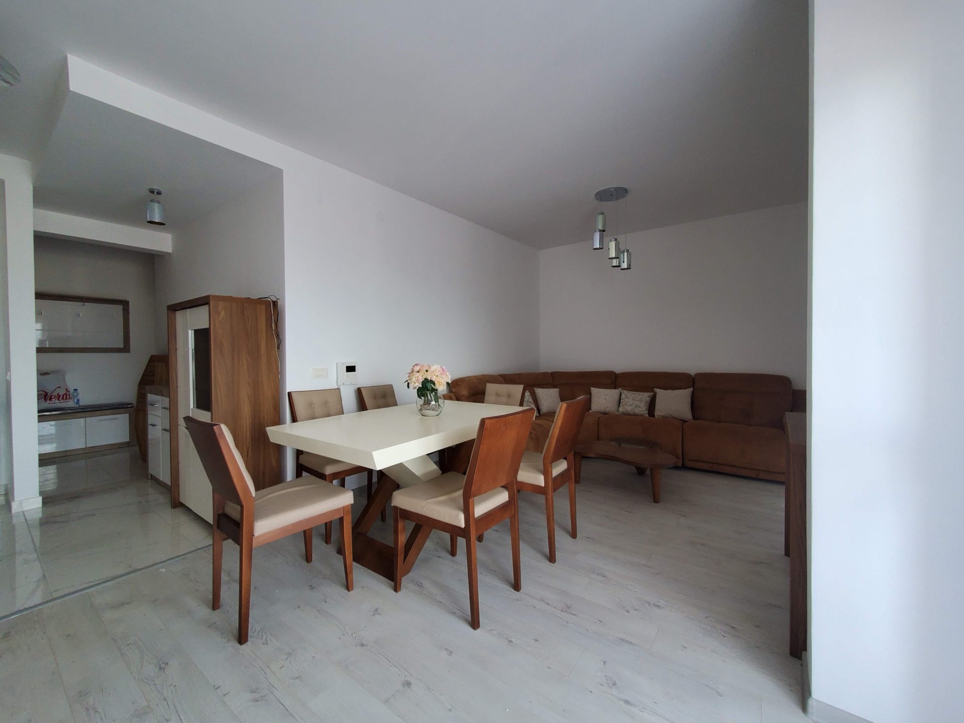 Living room with dining area and a brown sofa in an apartment in Budva, Montenegro. Modern interior with furniture.