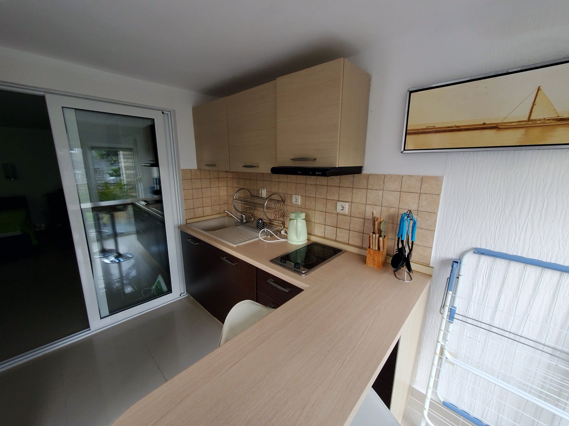 Kitchen in the Biela Hotel, Montenegro: light-colored cabinetry, built-in stove, breakfast bar, and access to the terrace.