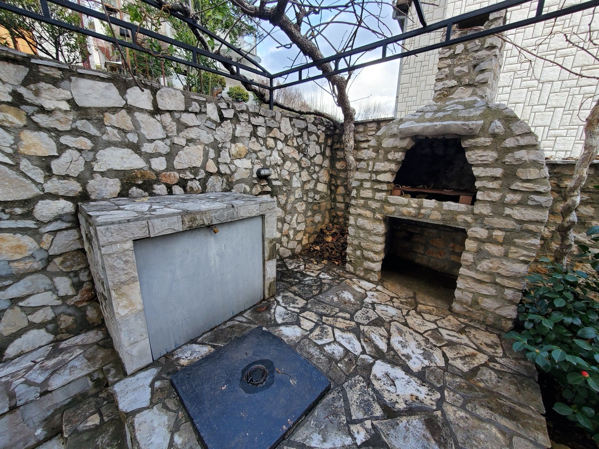 Barbecue area with a stone grill and terrace at a hotel in Bijela, Montenegro. Cozy courtyard with stone finishes.