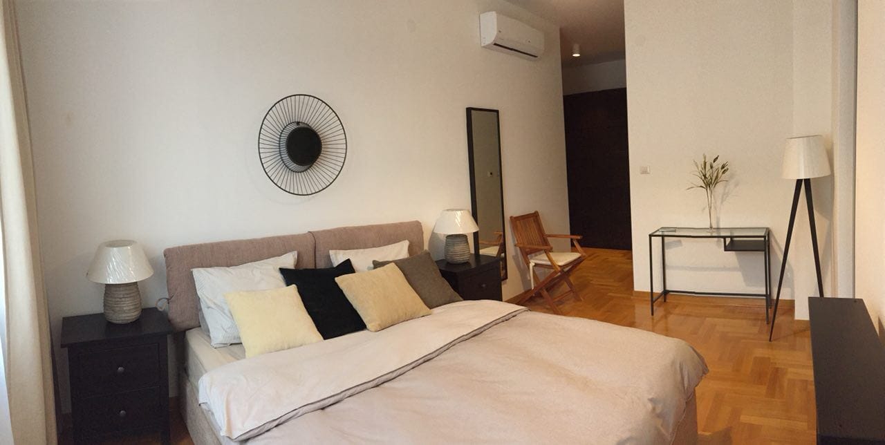 Bright bedroom with a double bed and parquet flooring in an apartment for sale, Morinj, Montenegro.