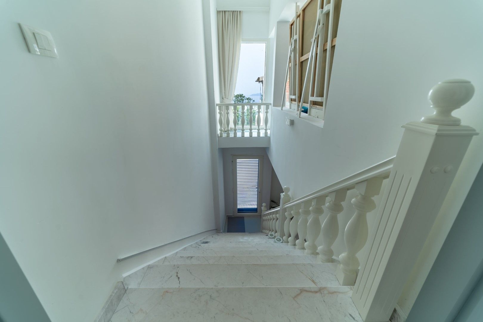 White marble staircase with classic balusters in a house, Blizikuće, Montenegro, view of the terrace and the sea.