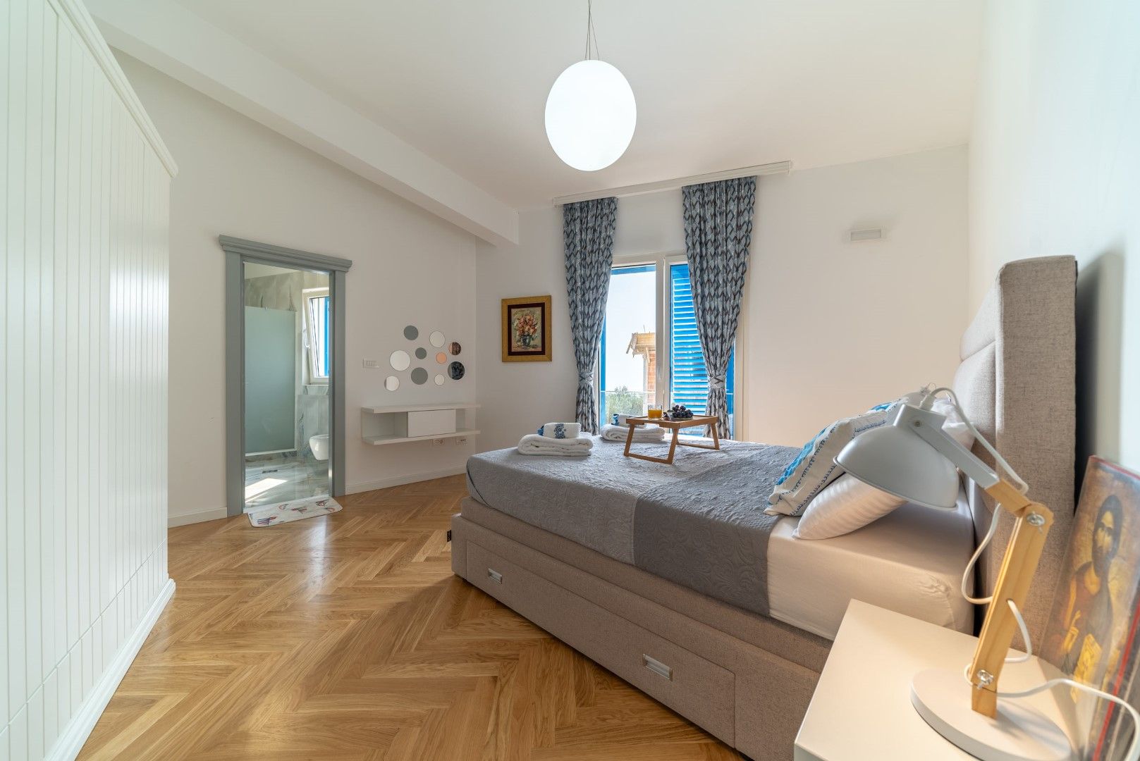 Bright bedroom with a double bed, parquet flooring, and access to the terrace in a house, Blizikuće, Montenegro.