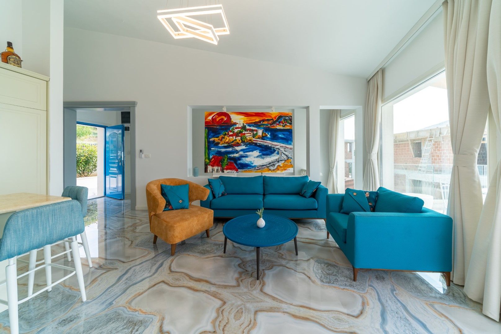Living room in a house in Blizikuće, Montenegro: bright furniture, marble floor, modern design, and a painting on the wall.
