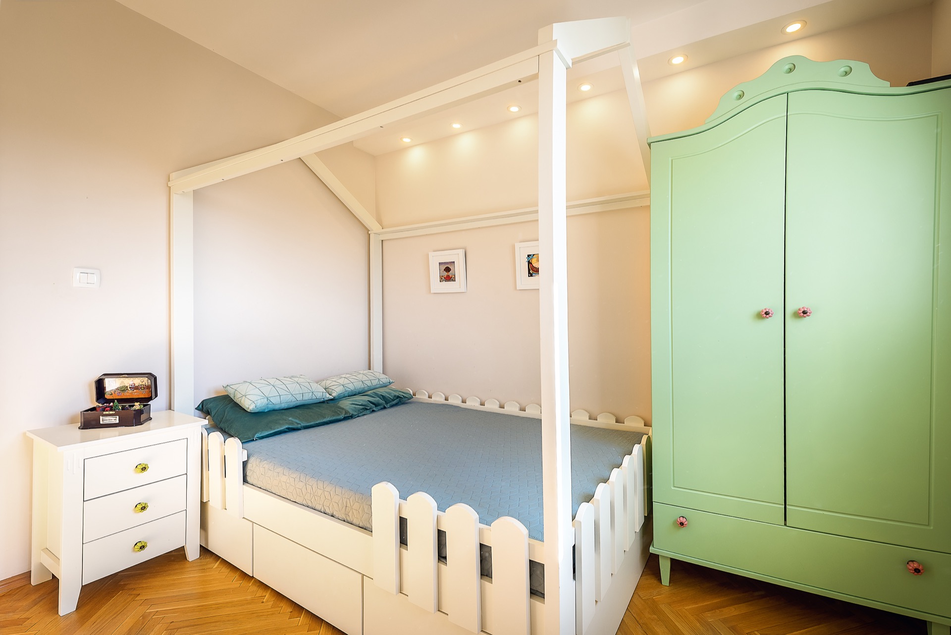 Children’s bedroom in an apartment in Budva, Montenegro: white house bed, mint wardrobe, and parquet floor.