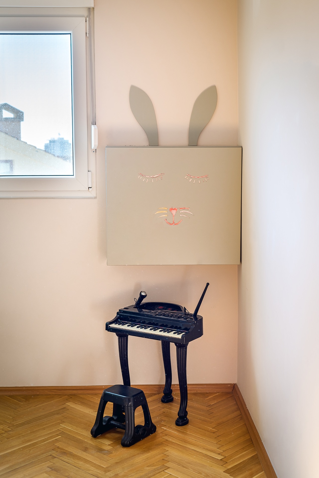 Children's bedroom in an apartment in Budva, Montenegro: wall decor in the shape of a rabbit, a children's piano, and parquet flooring.