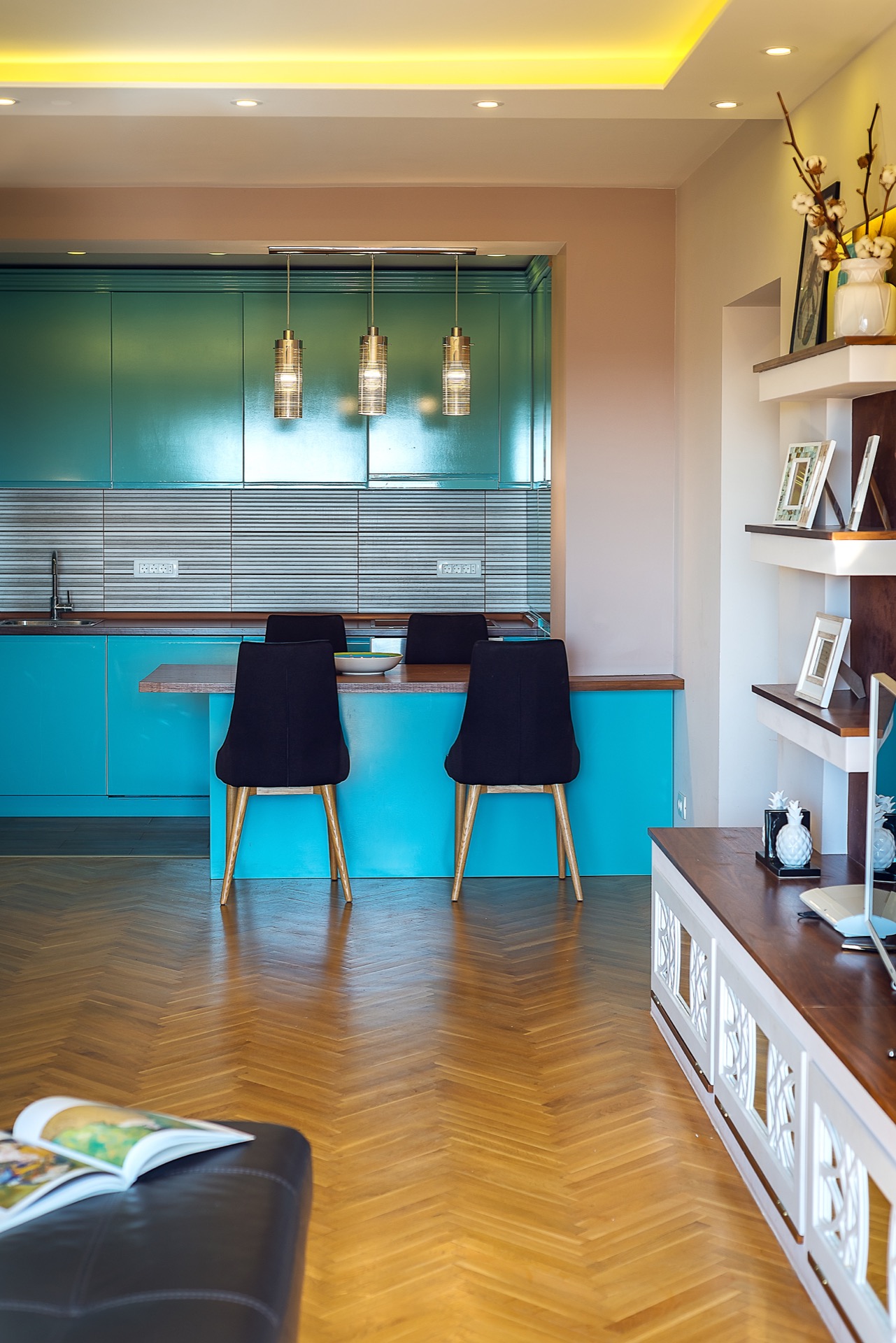 Modern kitchen with a turquoise cabinet set and parquet flooring in an apartment in Budva, Montenegro: dining area and stylish decor.