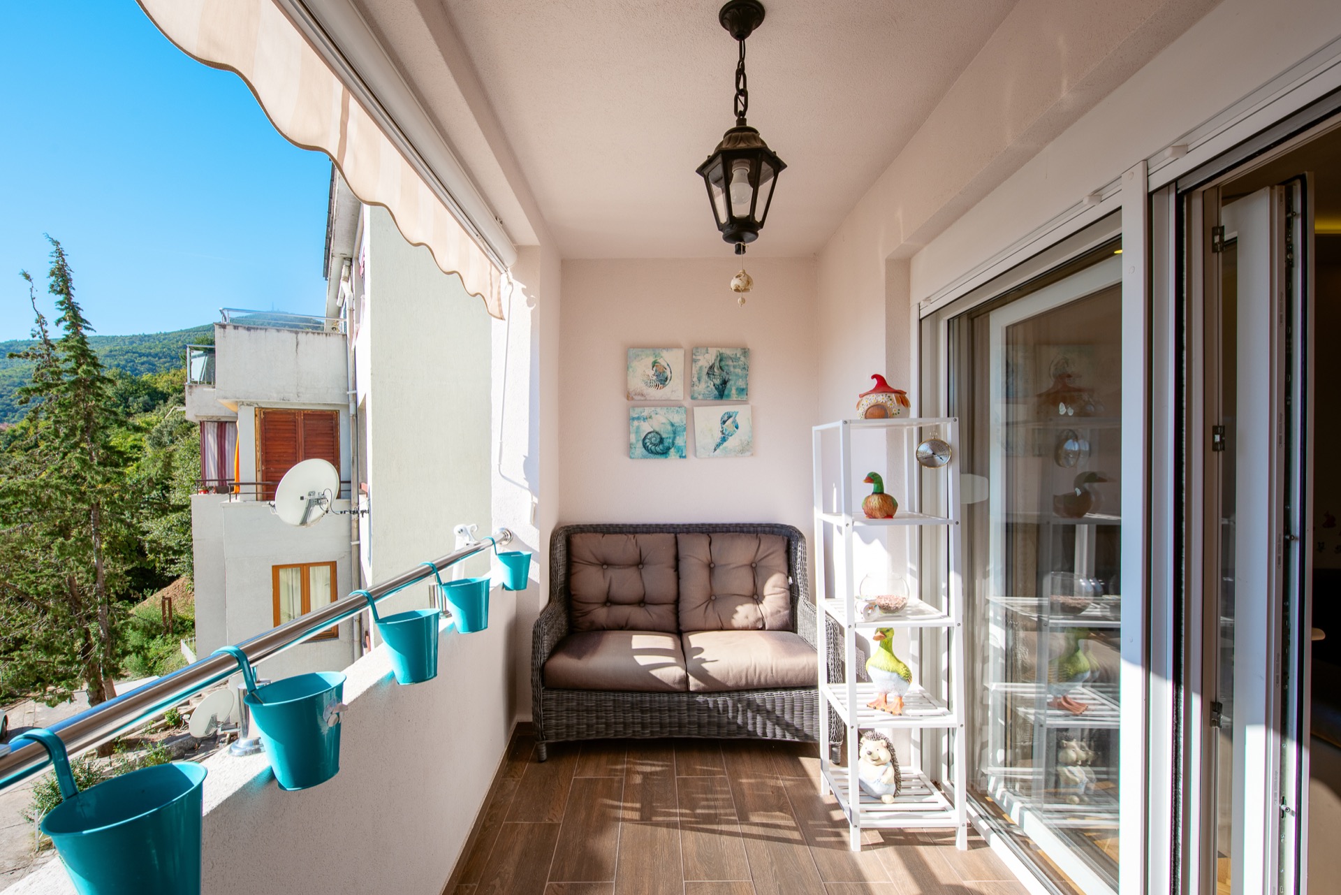 Cozy balcony with wicker furniture and mountain views in an apartment, Budva, Montenegro.