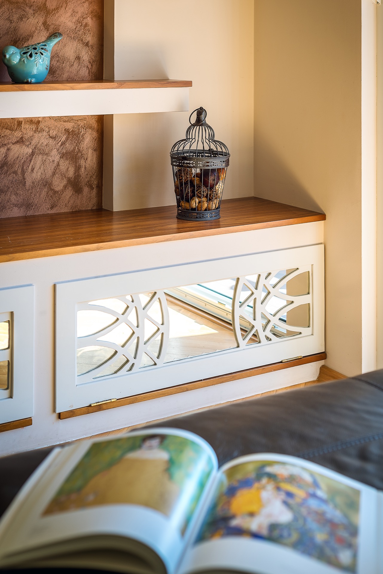 Living room decor in an apartment in Budva, Montenegro: a wooden cabinet with carved fronts and stylish accessories.