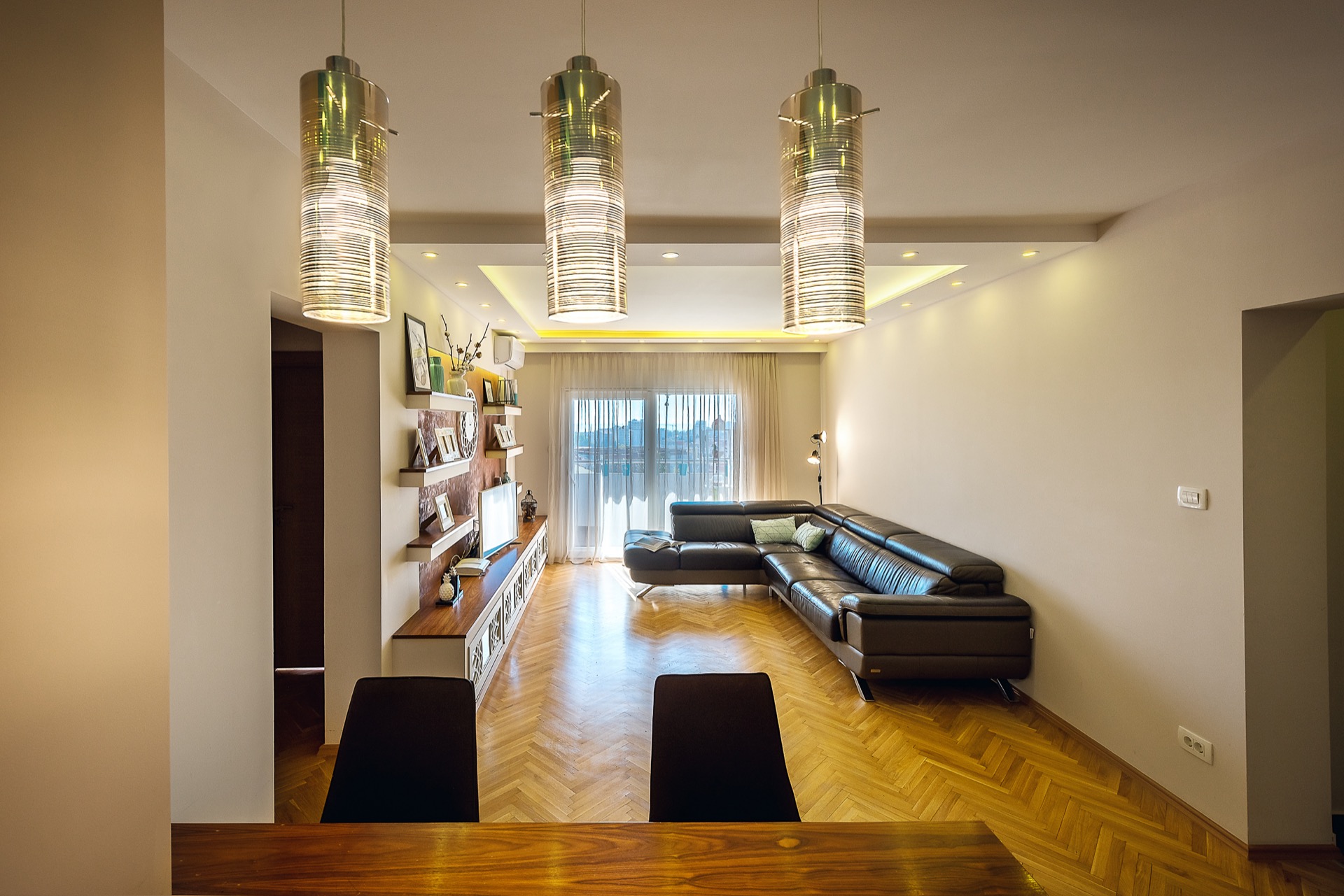Modern living room with a leather sofa and parquet flooring in an apartment for sale, Budva, Montenegro.