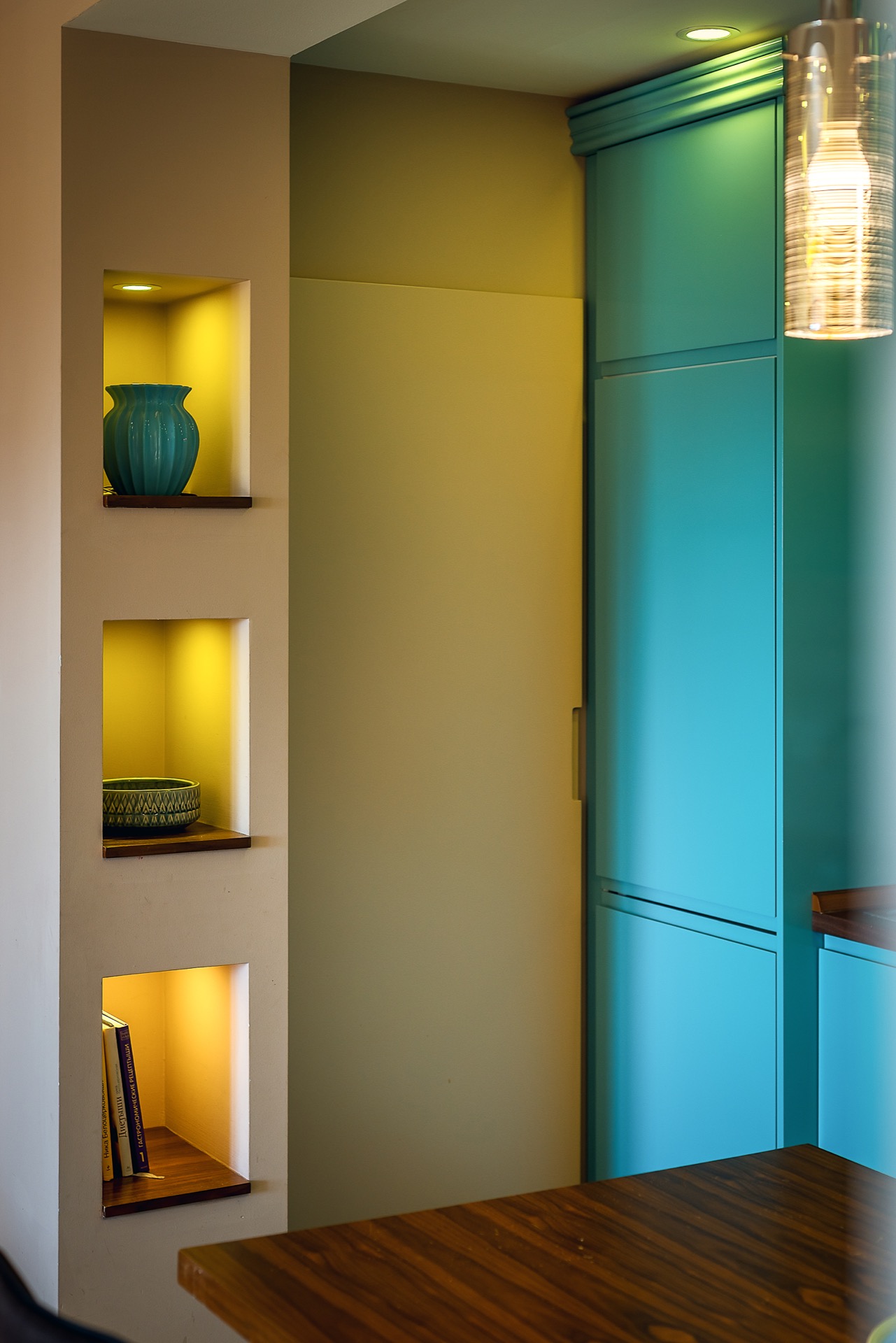 Modern kitchen in an apartment in Budva, Montenegro: turquoise cabinet fronts, built-in niches with lighting, and decor.