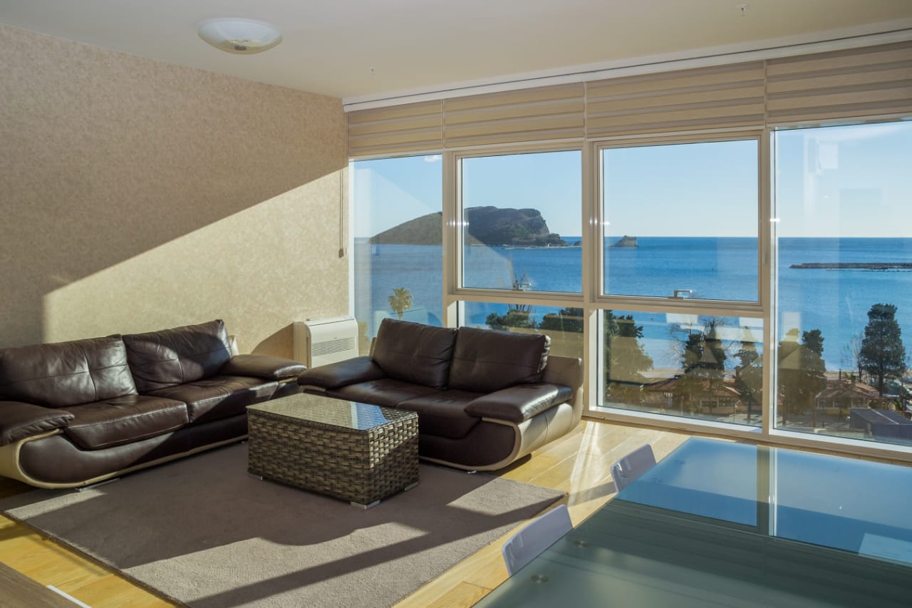 Living room with leather sofas and panoramic sea view in an apartment, Budva, Montenegro.