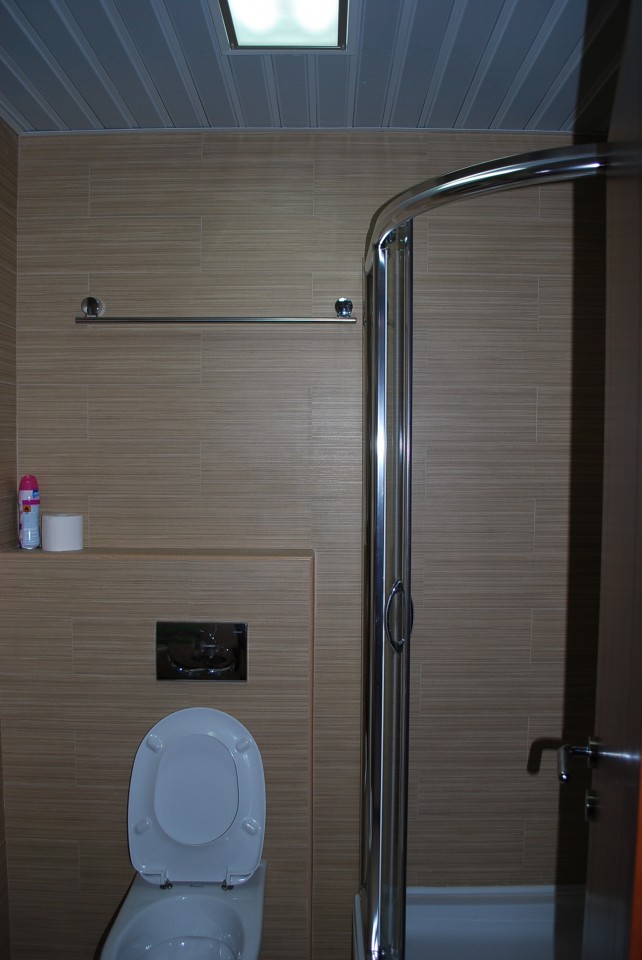 Modern bathroom with a shower cabin and wood-style finishes in an apartment, Budva, Montenegro.