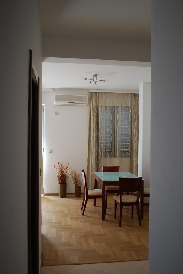 Bright living room with dining area and parquet flooring in an apartment for sale in Budva, Montenegro.