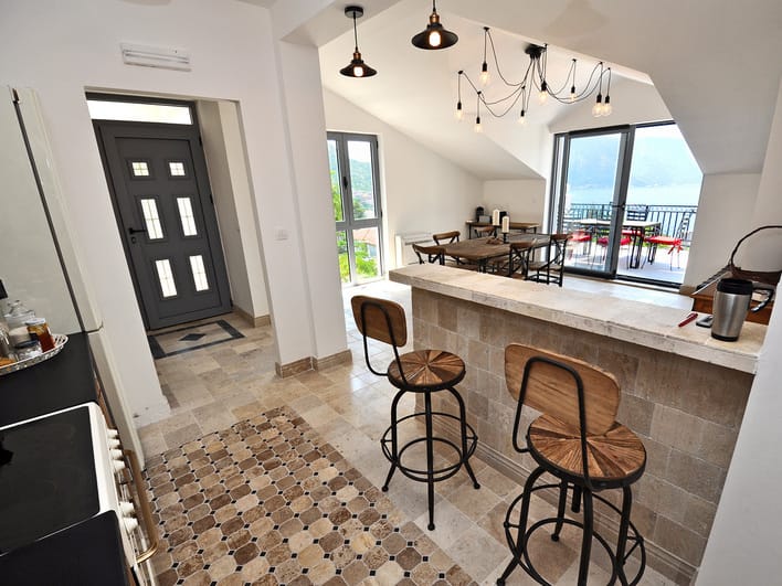 Kitchen with a breakfast bar and sea view in an apartment in Risan, Montenegro: stylish interior with stone finishes.