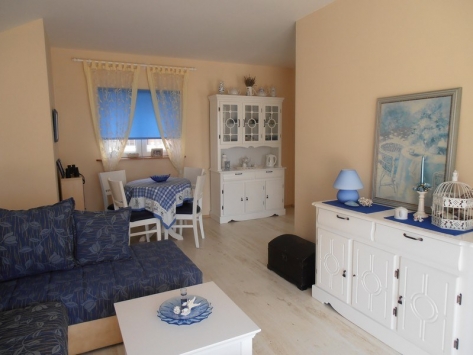 Cozy living room with white furniture and blue textiles in a villa in Luštica, Montenegro: bright interior, dining area.