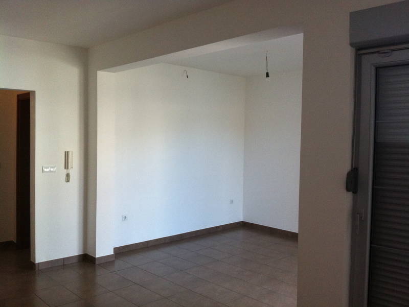 Bright living room with tile in a new apartment in Petrovac, Montenegro: finished interior, access to the balcony, interior view.