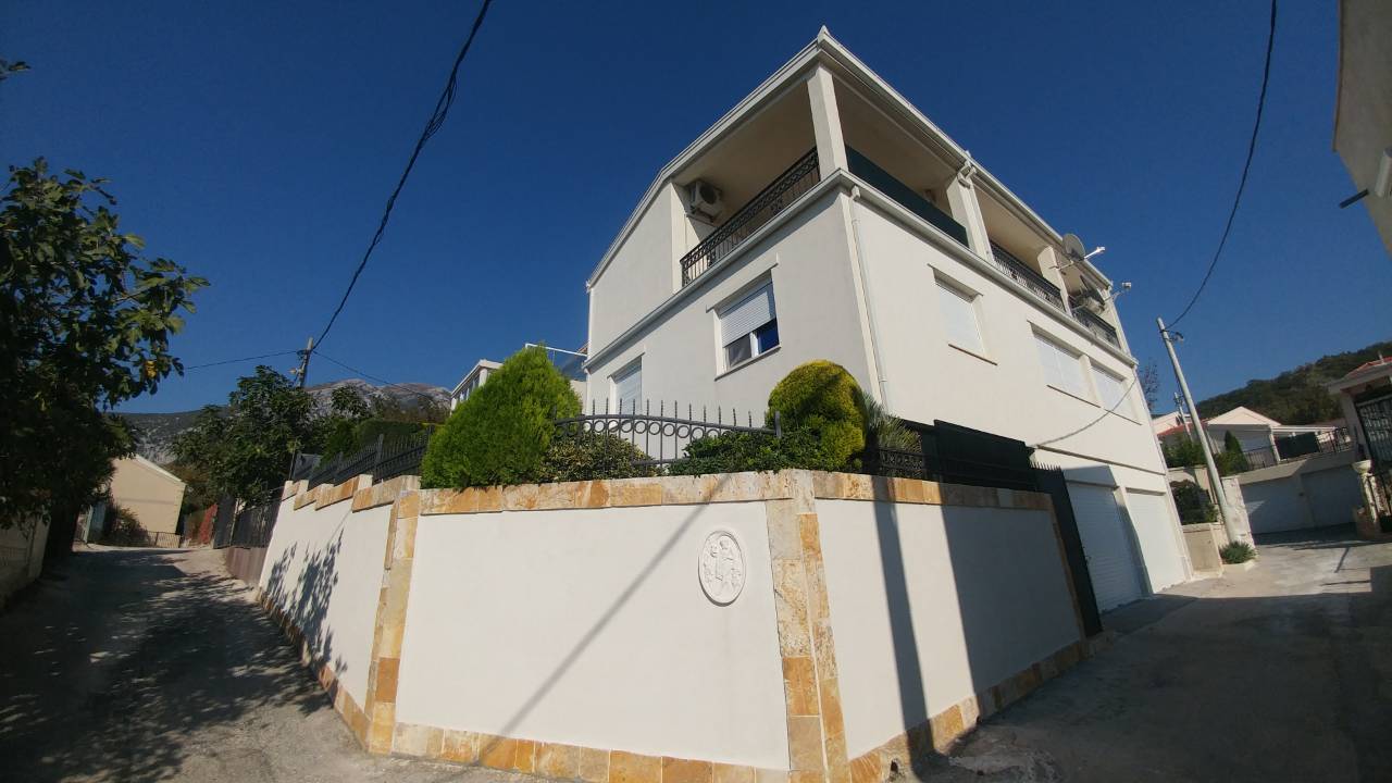 Three-story house with terraces and a stone fence in Ratac, Bar Riviera, Montenegro: exterior view of the facade.