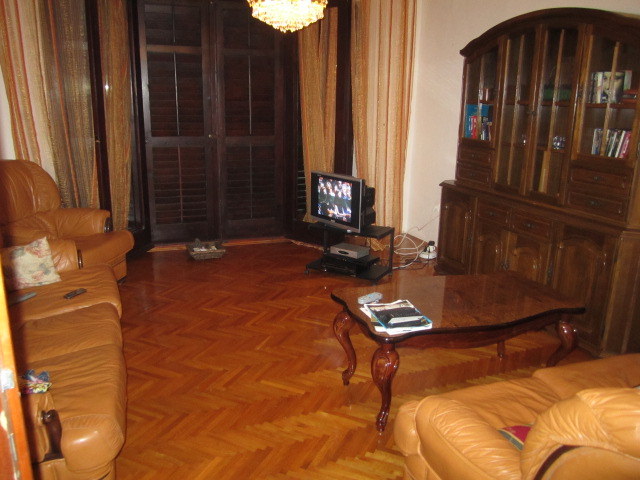 Classic-style living room in a house in Tivat, Montenegro: leather furniture, a wooden sideboard, and parquet flooring.