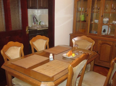 Dining area with a wooden table and sideboard in a house for sale, Tivat, Montenegro. Classic living room interior.