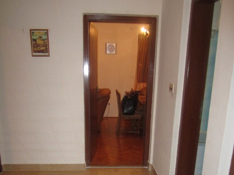 View from the hallway into the living room with parquet flooring and furniture in a house for sale in Tivat, Montenegro.