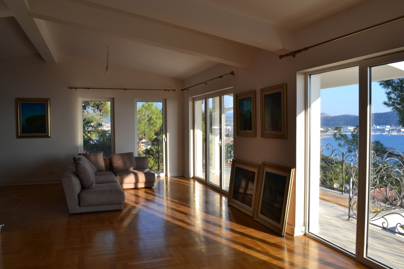 Living room in a house in Shushan, Montenegro: a bright room with parquet flooring, a soft sofa, and a panoramic sea view.