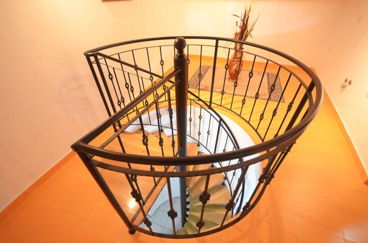 Spiral staircase with wrought-iron railings and wooden steps in a house, Krashichi, Montenegro.