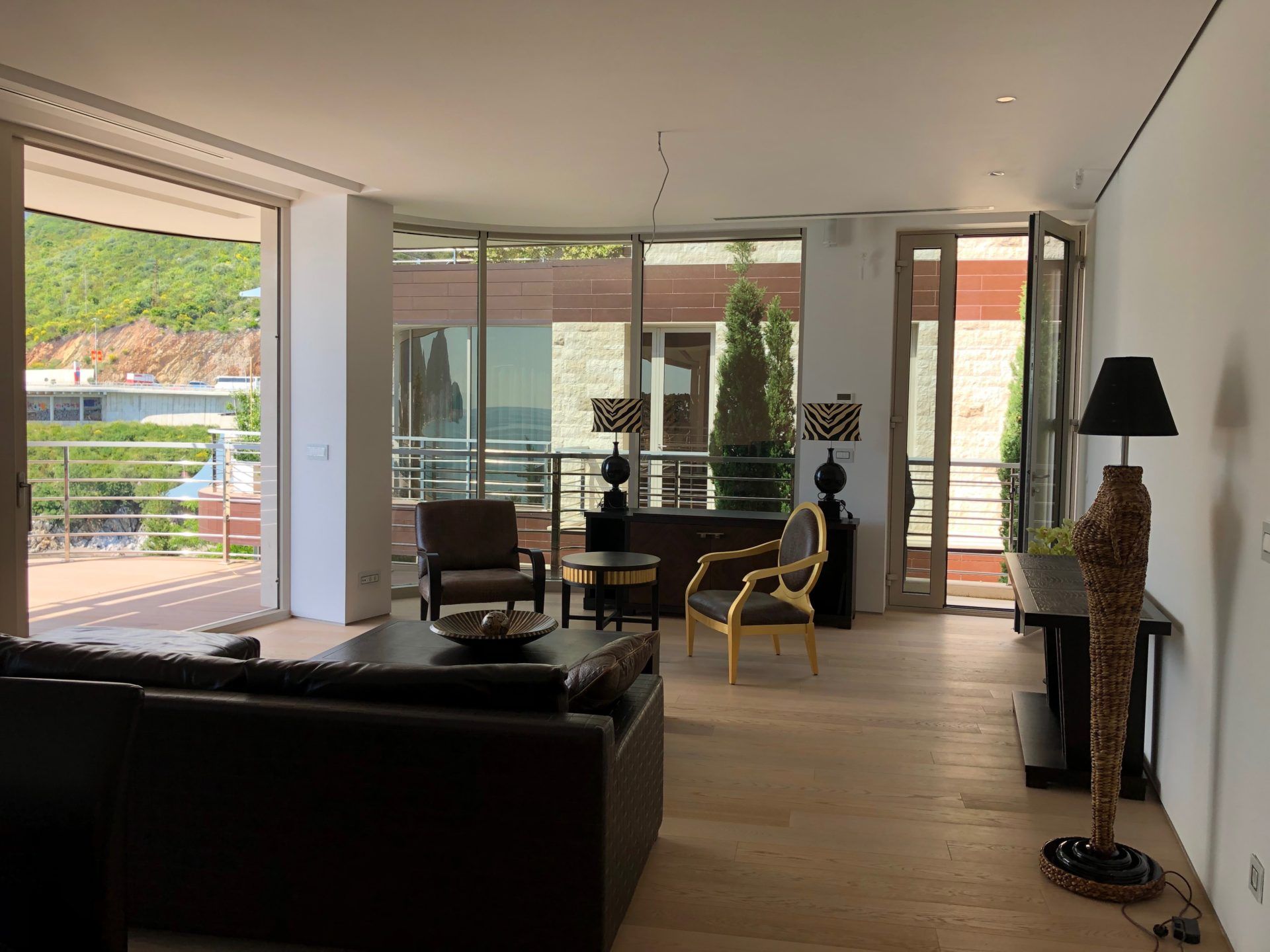 Spacious living room with panoramic windows and a terrace in a luxury apartment, Budva, Montenegro. Modern interior.