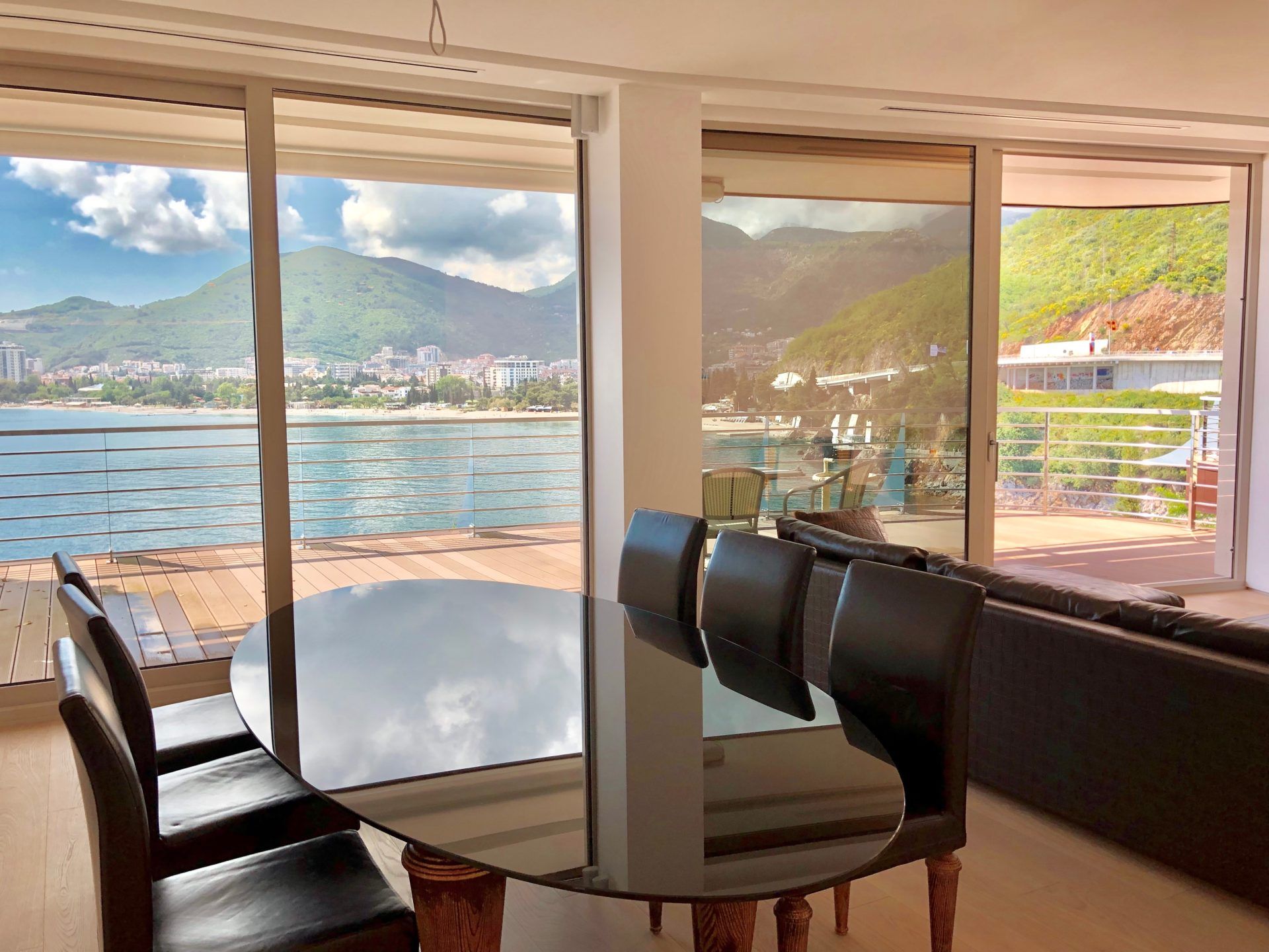 Living room with panoramic sea and mountain views in an apartment in Budva, Montenegro: dining table and terrace.