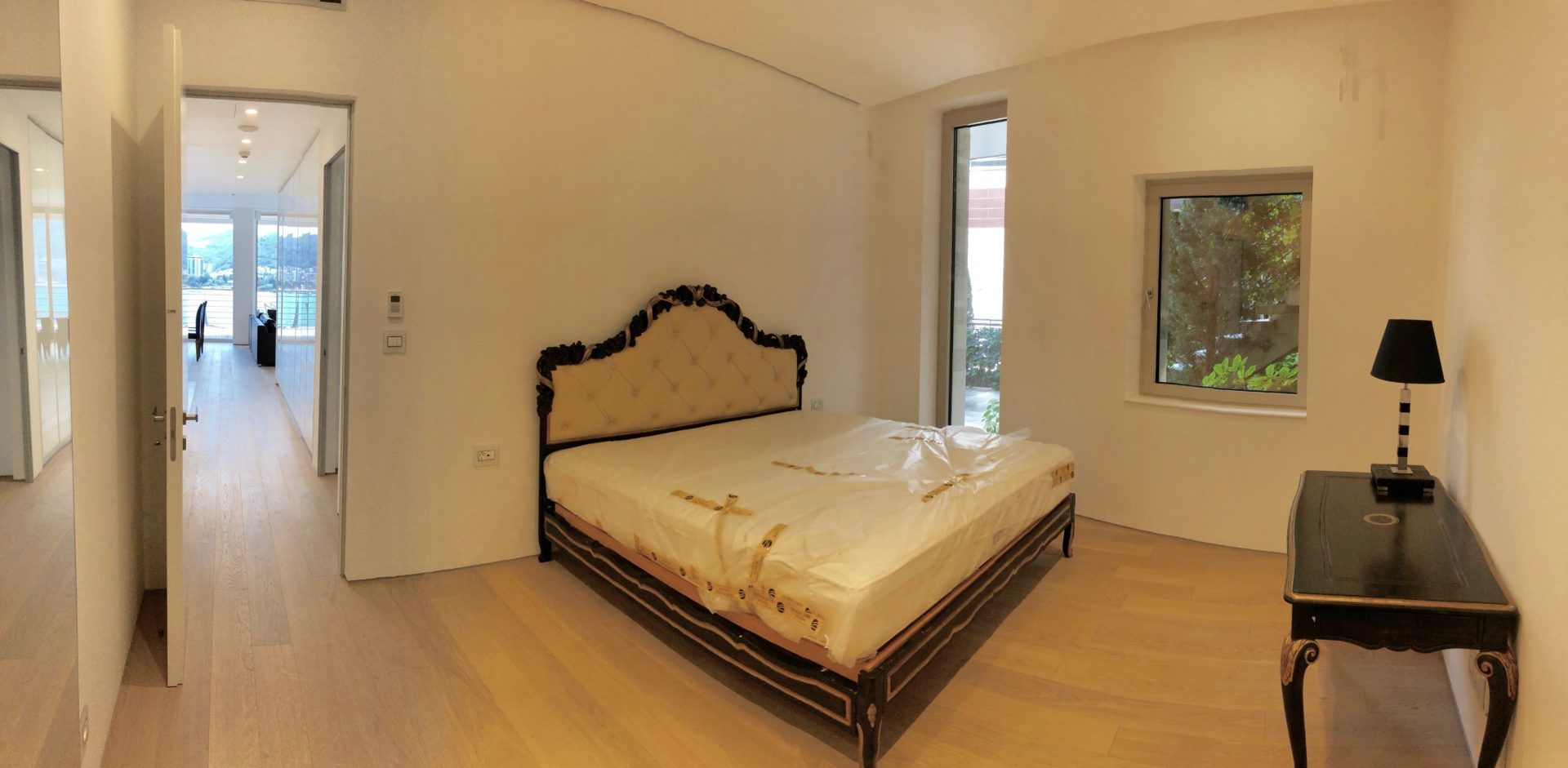 Bedroom in a modern apartment in Budva, Montenegro: a double bed with a soft headboard and sea view.