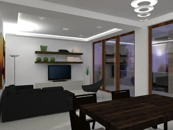 Modern living room with black sofa, wall-mounted TV, shelves, and dark wooden dining table near glass doors.
