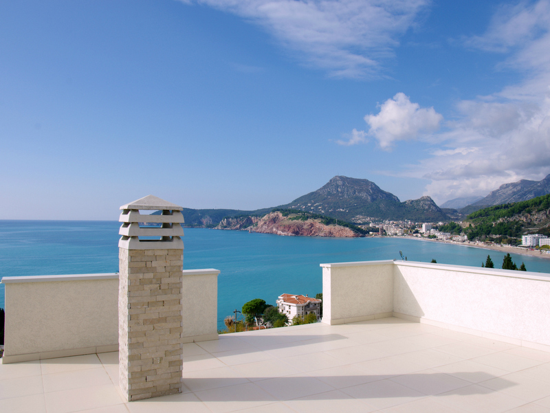Spacious terrace with sea and mountain views in a house, Sutomore, Bar Riviera, Montenegro. Light tiles and a chimney.