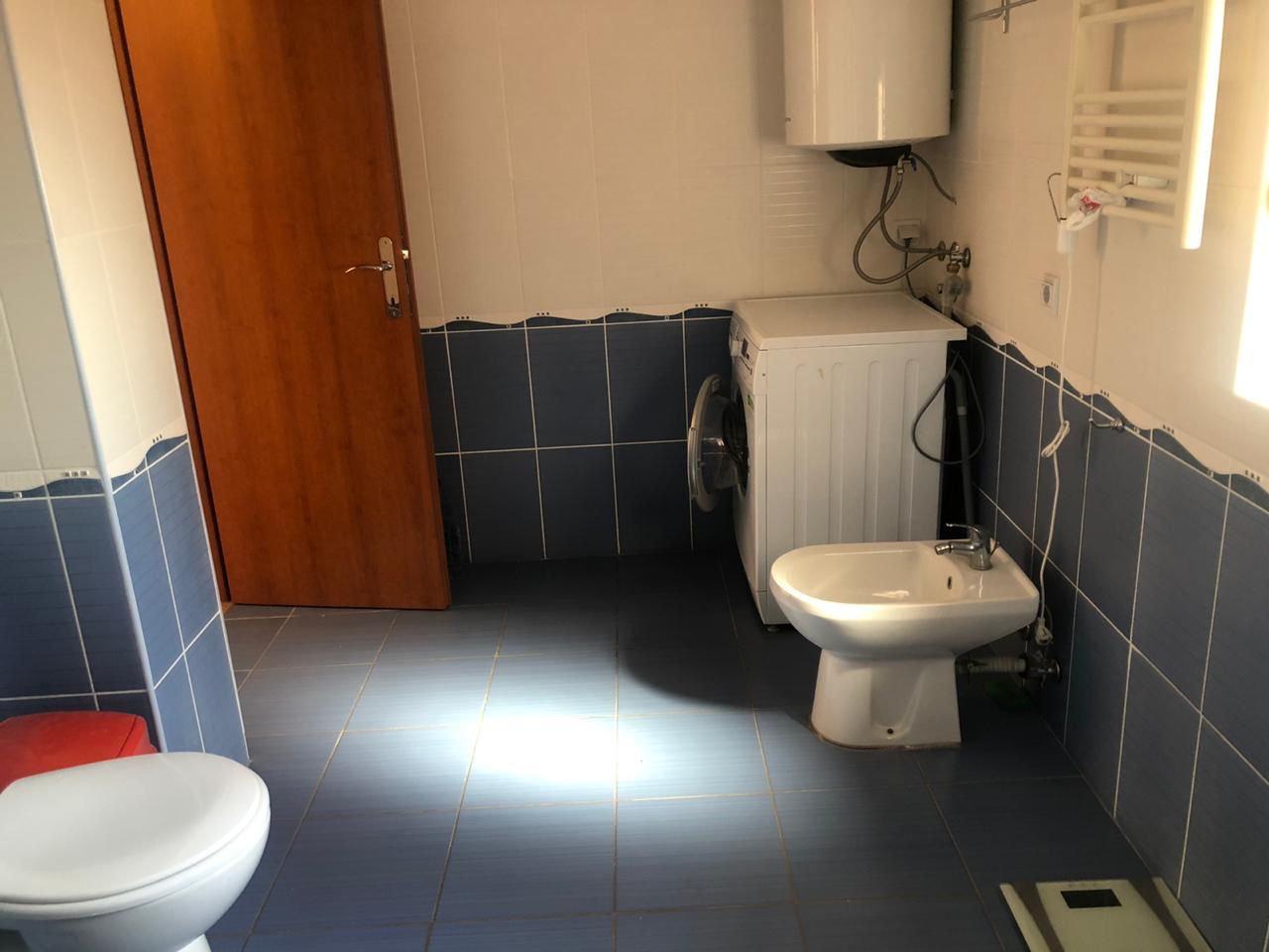 Bathroom in an apartment in Bečići, Montenegro: blue tiles, bidet, washing machine, and water heater.