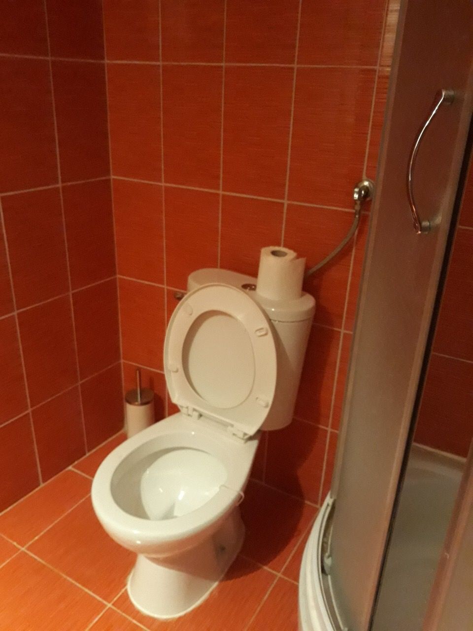 Bathroom with orange tiles and a shower cabin in a house, Zanjice, Montenegro.