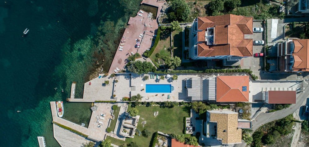 Aerial view of a villa in Krašići, Montenegro: private pool, terrace, private pier, and direct access to the sea.