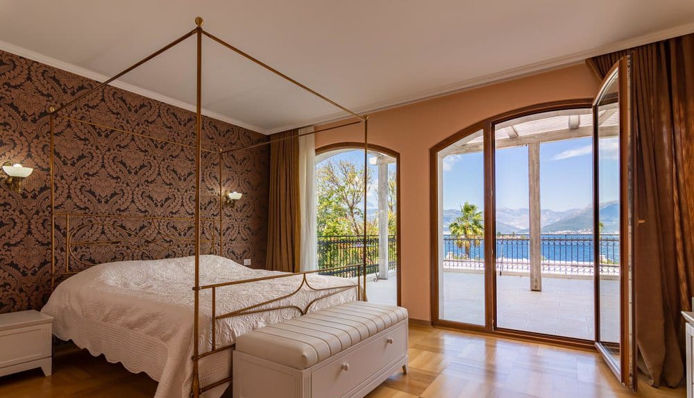 Bedroom with a canopy bed and sea view in a villa in Krašići, Montenegro: stylish interior and terrace.