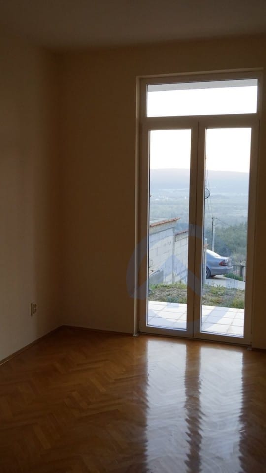 Bright living room with parquet flooring and access to the terrace in a house, Kavac, Montenegro. Mountain and surrounding area views.