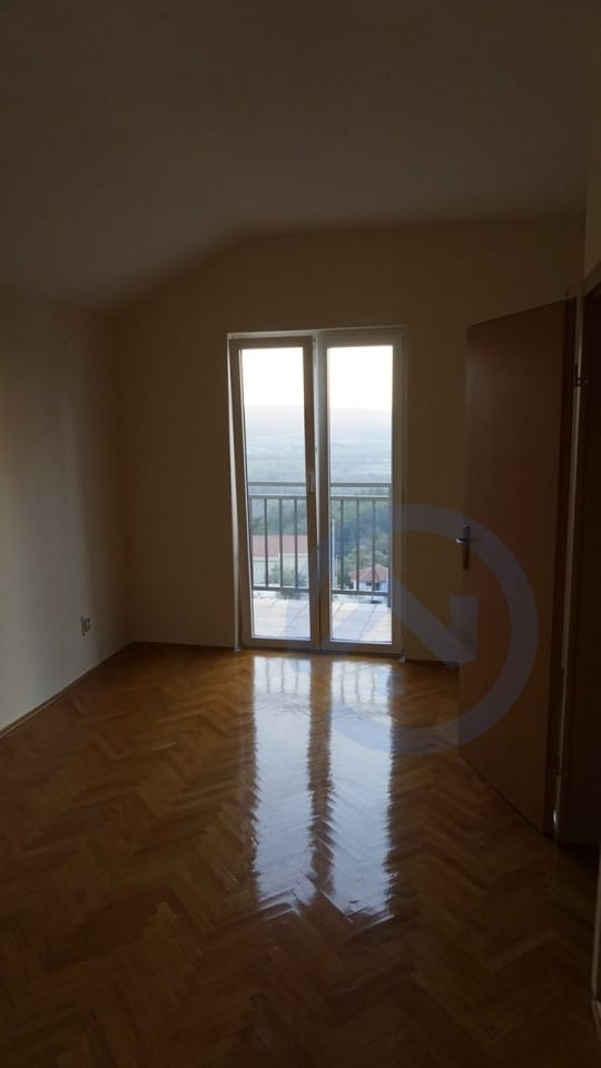 Bright bedroom with parquet flooring and access to a balcony with mountain views in a house, Kavac, Montenegro.