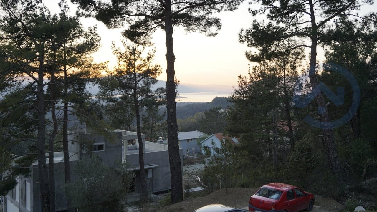 Sea and pine forest view from a house in Kavac, Montenegro: an object under construction and a panoramic sunset landscape.