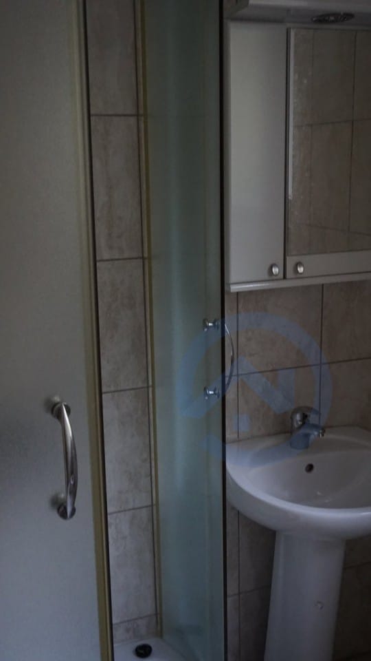 Bathroom with shower cabin and sink in a house, Kavac, Montenegro: modern tile finish and mirror.