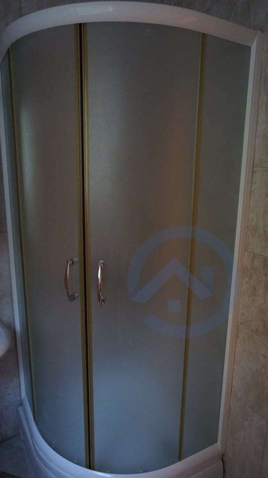 Corner shower cabin with frosted glass in the bathroom of a house in Kavac, Montenegro.