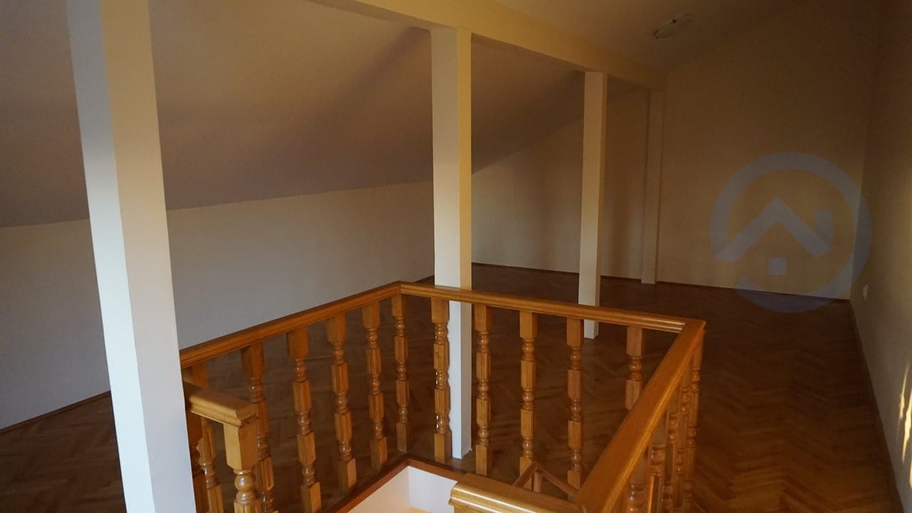 Spacious attic room with wooden parquet flooring and a staircase in a house, Kavac, Montenegro.