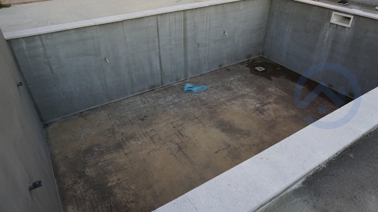 Concrete pool under construction on a house plot in Kavac, Montenegro: view of the pool basin during finishing.