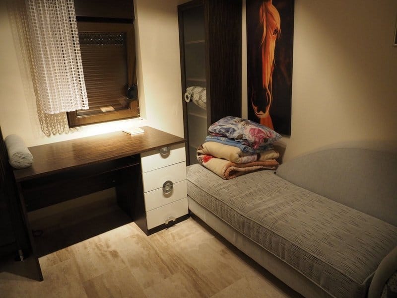 Bedroom in a villa in Stoliv, Montenegro: a single bed, a desk with a side cabinet, and a wardrobe in a modern interior.
