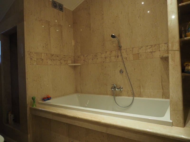 Bathroom with beige marble finishes in a villa, Stoliv, Montenegro: built-in bathtub and high-quality renovation.